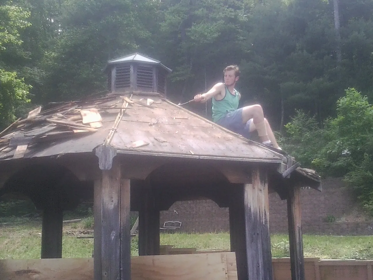 Tearing the old roof off a wooden gazebo before new shakes in West Long Branch