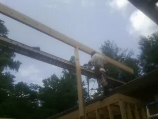 Carpenter setting a ridge beam over a new addition frame — Ice Dam Removal by Roofing Brothers in West Long Branch