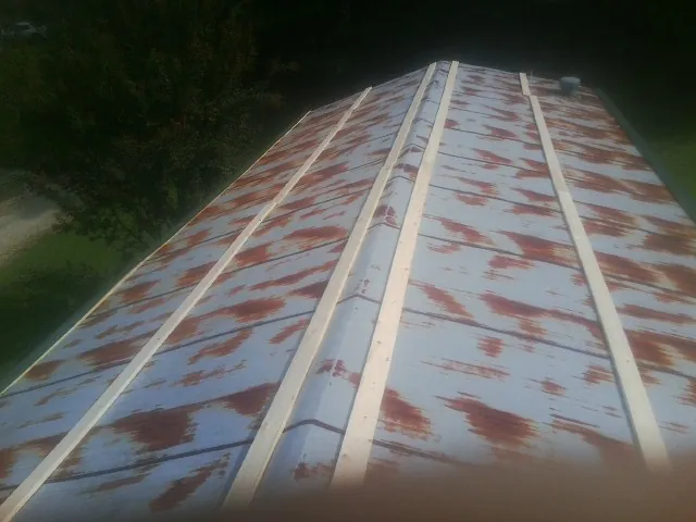 Rusted metal roof panels with new wood purlins before replacement — Storm Damage Roof Repair in West Long Branch by Roofing Brothers