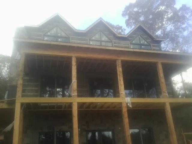 Dormers and porch framing on a large log home under construction — Roof Coating work by our crew in West Long Branch