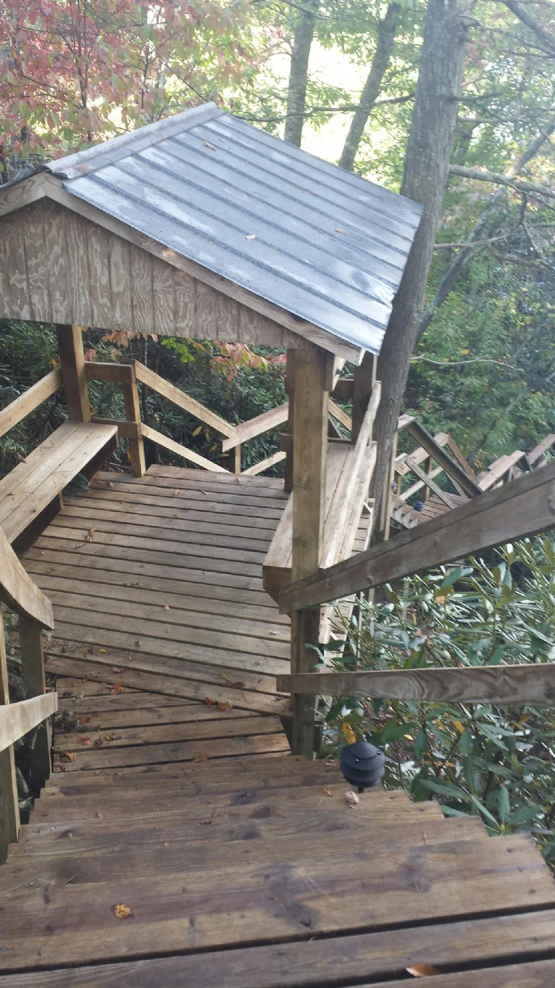 Metal roofed shelter over wooden steps on a wooded walkway — Skylight Repair & Installation work by our crew in West Long Branch